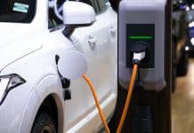 Power supply for electric car charging. Electric car charging station. Close up of the power supply plugged into an electric car being charged.