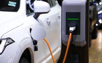 Power supply for electric car charging. Electric car charging station. Close up of the power supply plugged into an electric car being charged.