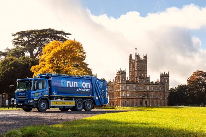 The electric waste collection vehicle is pictured in front of Highclere Castle, one of Grundon's customers